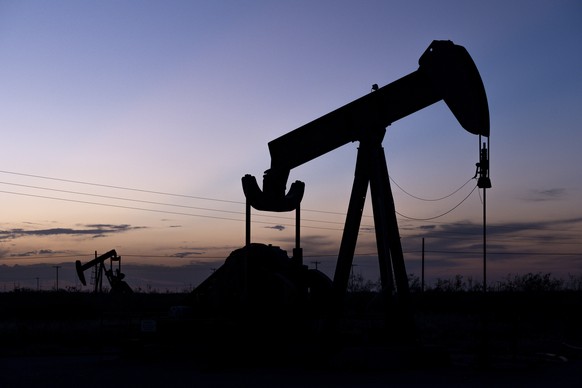 The hints of sunlight begin to disappear behind a pair of pumpjacks Wednesday, Sept. 15, 2021 in the oilfields of Penwell, Texas. A movement to divest from fossil fuels is gaining momentum among found ...