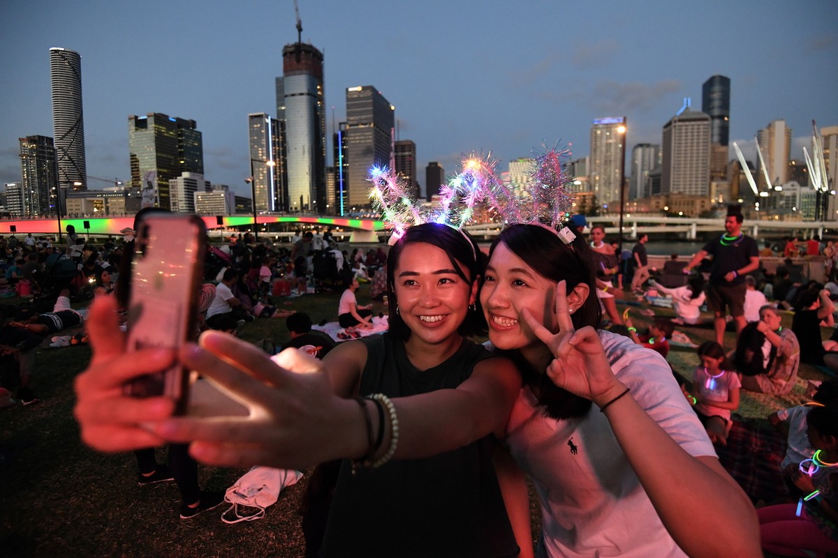 epa08095693 Mizuki (L) and Tsubasa take a selfie as they wait to watch the New Year's Eve fireworks at Southbank in Brisbane, Australia, 31 December 2019. EPA/DAN PELED AUSTRALIA AND NEW ZEALAND  ...