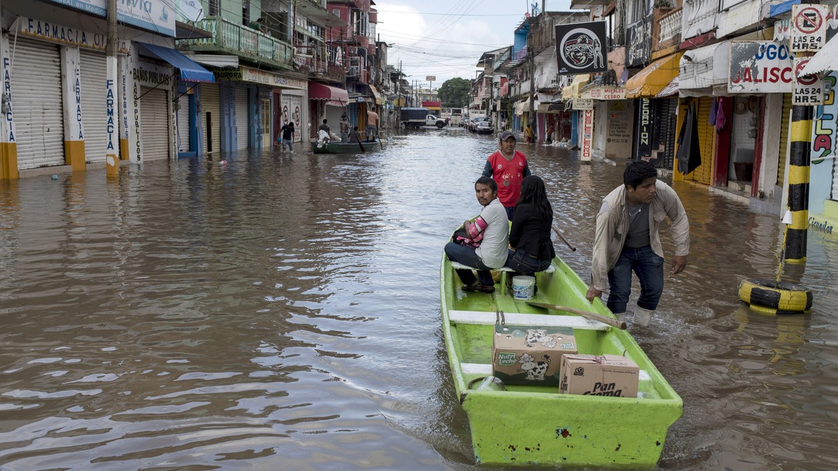 epa07114558 Inhabitants of the city of Minatitlán, in the state of Veracruz, Mexico, use boats to cross streets flooded by storms that affect much of Mexican territory, in addition to the arrival of H ...