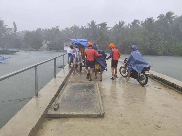 epa12513324 A handout photo made available by the Philippine Coast Guard (PCG) shows PCG personnel assisting residents in pre-emptive evacuation measures in anticipation of the effects of typhoon Fung ...