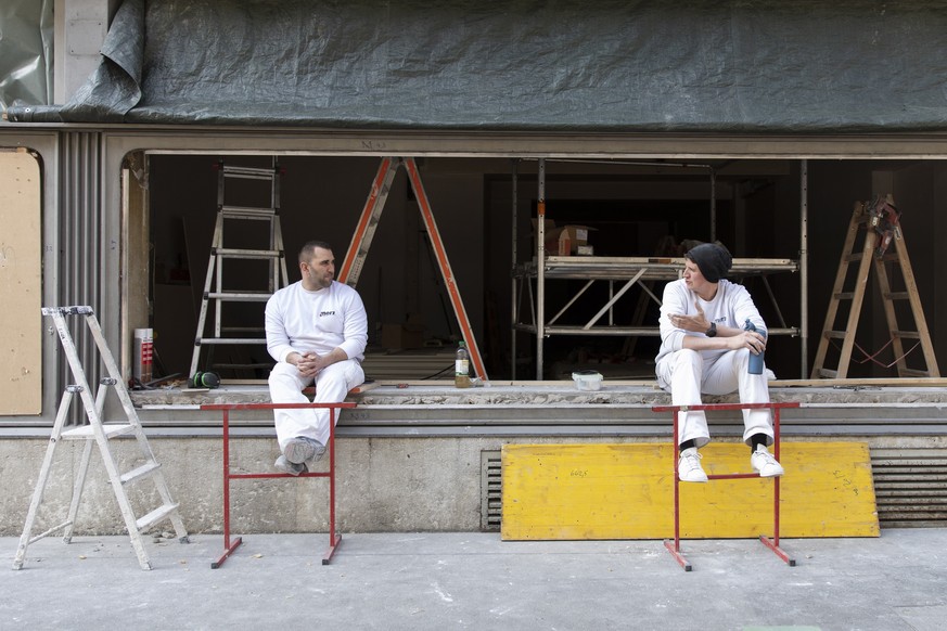 epa08309116 Two plasterers keep a safetey distance between themselves while taking a break, in Bern, Switzerland, 20 March 2020. People all over the alpine nation were invited to take part in the  ...