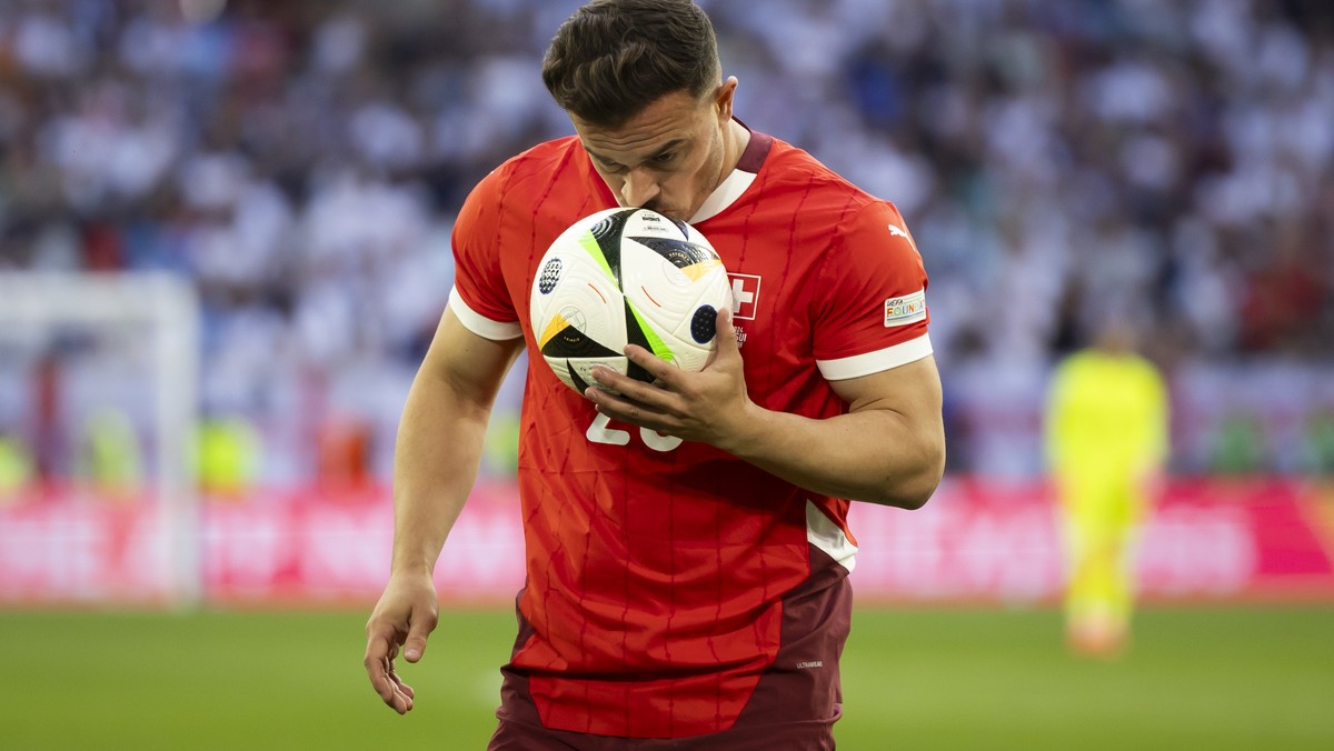 Switzerland's Xherdan Shaqiri kisses the ball before taking a corner kick during the quarter final match between England and Switzerland at the Euro 2024 soccer tournament in Duesseldorf, Germany ...