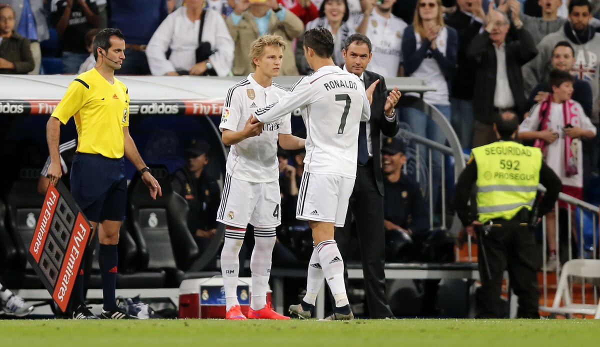 Real Madrid's Cristiano Ronaldo embraces Real Madrid's Martin Odegaard from Norway, center left, as he leaves the field during a Spanish La Liga soccer match between Real Madrid and Getafe a ...