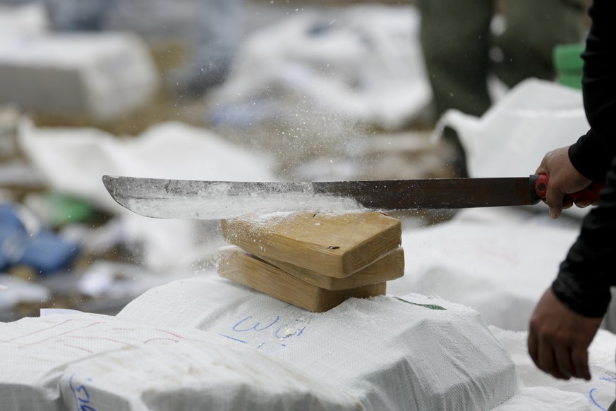 A police officer cuts open packages of cocaine with a machete before burning them in Panama City, Friday, Oct. 1.  16, 2015. According to the National Police, they destroyed at least 10 tons of cocaine...