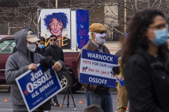 epa08869113 The likeness of voting rights advocate Stacey Abrams a supporters participate in a campaign event with Democratic Georgia US Senate candidate Jon Ossoff and former US Housing and Urban Dev ...