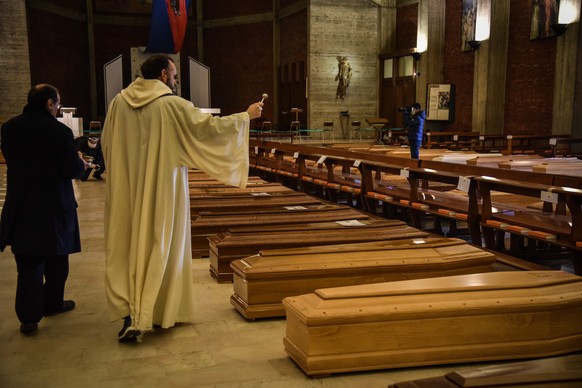 epaselect epa08328236 Coffins of people deceased from the COVID-19 novel coronavirus are being blessed inside the church of San Giuseppe in Seriate, Italy, on March 28, 2020. Italy is the country with ...