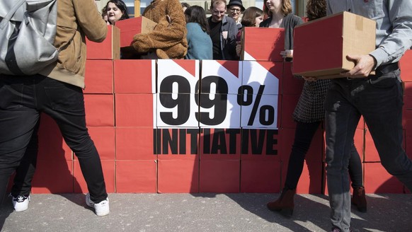Mitglieder der JUSO tragen die Schachteln mit den Unterschriften zur Bundeskanzlei, bei der Einreichung der 99-Prozent-Initiative, am Dienstag, 2. April 2019 in Bern. (KEYSTONE/Peter Klaunzer)