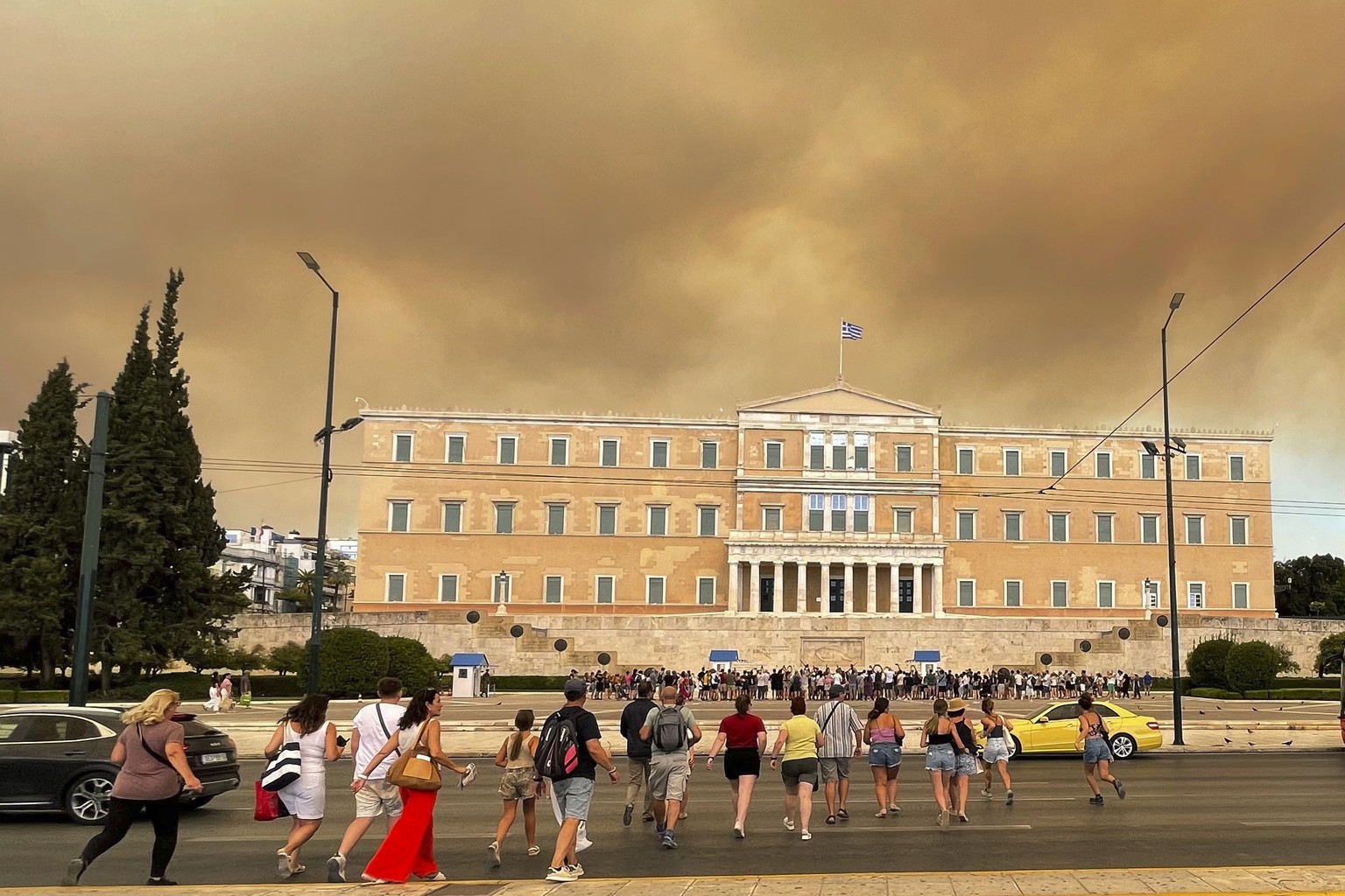 Smoke from wildfires is seen above the Greek parliament building in central Athens, Sunday, Aug. 11, 2024, after a blaze northeast of the capital forced evacuations in the area. (AP Photo/Derek Gatopo ...