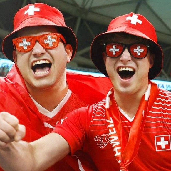 Football World Cup in Qatar Supporters wearing Swiss cross glasses cheer ahead of a World Cup round of 16 football match between Portugal and Switzerland at Lusail Stadium in Lusail, Qatar, on Dec. 6. ...