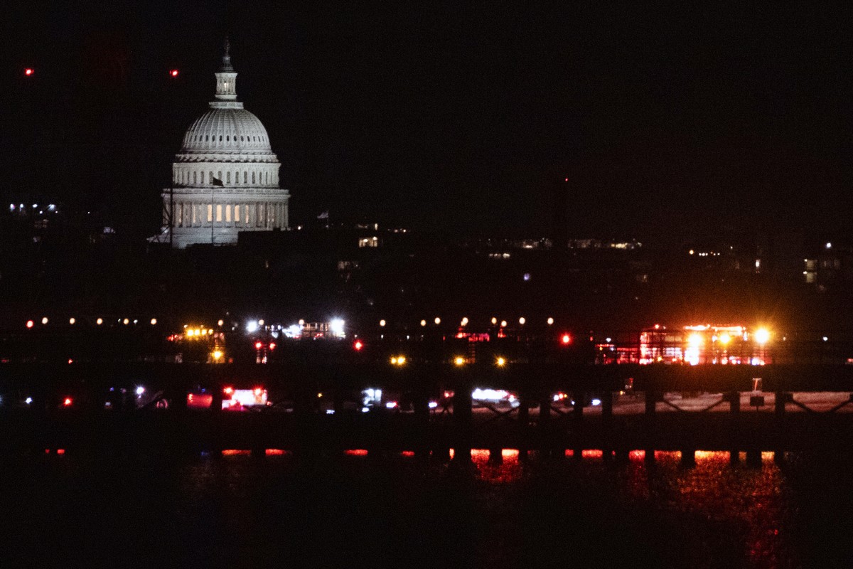 Emergency vehicles stage at Ronald Reagan Washington National Airport Wednesday night, Jan. 29, 2025, in Arlington, Va. The U.S. Capitol is seen across the Potomac River in Washington. (AP Photo/Kevin ...