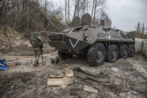 Ukrainian serviceman walks past an abandoned Russian&#039;s army military vehicle in a road near Chernobyl, Ukraine, Tuesday, April 5, 2022. (AP Photo/Oleksandr Ratushniak)