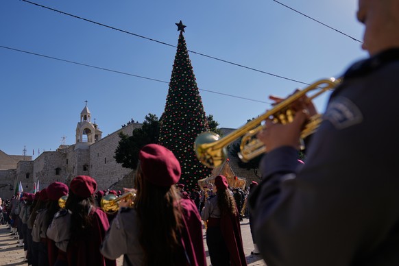 Palestinian scout bands parade at the Manger Square near the Church of the Nativity, traditionally believed to be the birthplace of Jesus, on Christmas Eve, in the West Bank city of Bethlehem, Wednesd ...