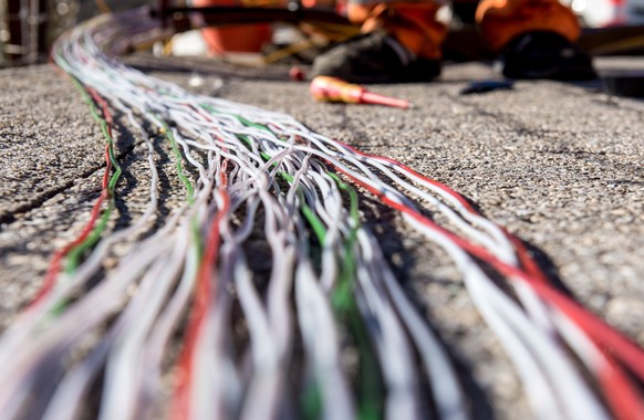 Ein Arbeiter montiert Glasfaserkabel der Swisscom fuer den Internetansschluss von Privathaushalten, am Dienstag, 10. Februar 2015 in Bellinzona. Die staedtischen Betriebe Bellinzona &quot;Aziende Muni ...