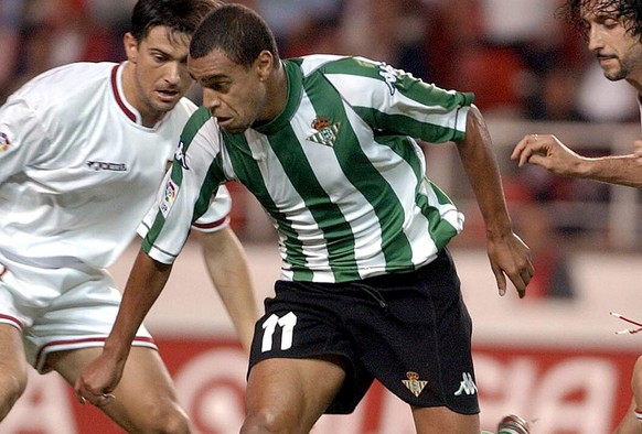 Real Betis&#039; Brazilian player Denilson, center, dribbles the ball between Seville&#039;s Pabro Alfaro, right, and Marti in a Spanish league soccer match in Seville, Spain Sunday Oct. 19, 2003. (AP ...