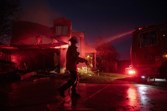 A firefighter assesses the damage of a home from the Tick Fire, Thursday, Oct. 24, 2019, in Santa Clarita, Calif. The dramatic fires and evacuations â?? near Los Angeles and in the wine country of Nor ...