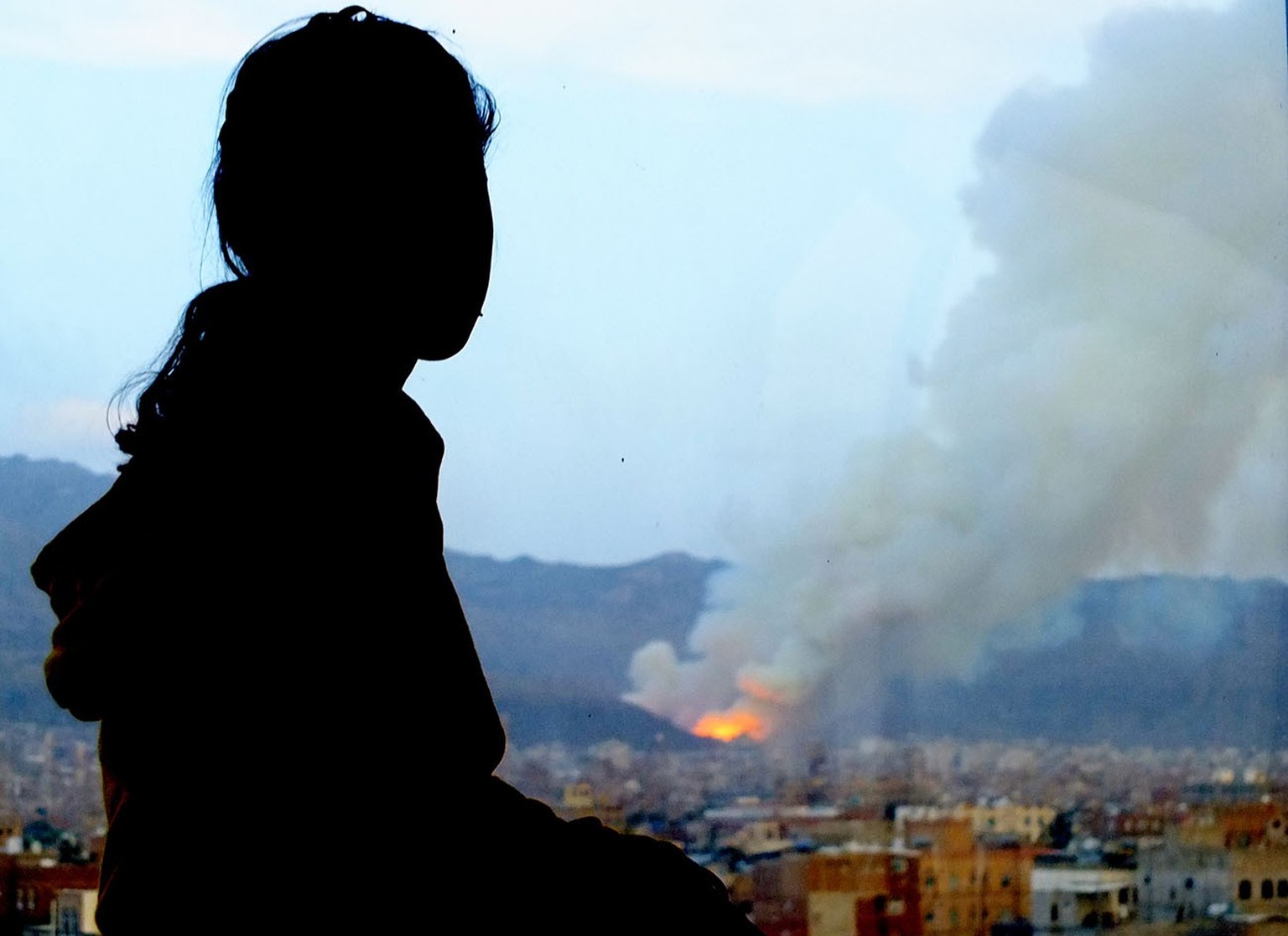 This photo shows Amal who is looking at her destroyed home in Sana’a after it was hit by an airstrike in April 2015.