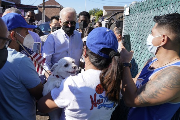President Joe Biden talks with people as he tours a neighborhood impacted by flooding from the remnants of Hurricane Ida, Tuesday, Sept. 7, 2021, in the Queens borough of New York. (AP Photo/Evan Vucc ...