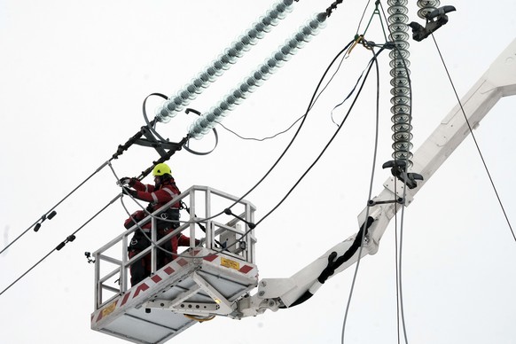 epa11882546 Specialists cut a loop of power line next to the border of Russia, Latvia, 08 February 2025. The Baltic states of Lithuania, Latvia, and Estonia on 08 February cut ties with Russia's  ...