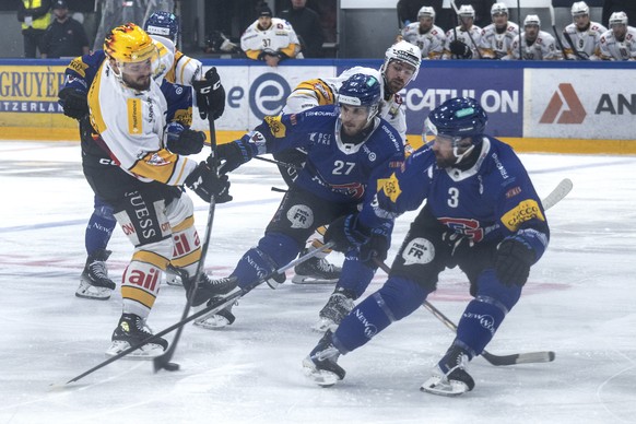 PostFinance Top Scorer Luca Fazzini (HCL), lnks, im Duell mit Yannick Rathgeb (HCFG), Mitte, und Michael Kapla (HCFG) im Eishockey Spiel der National League zwischen dem HC Fribourg Gotteron und dem H ...