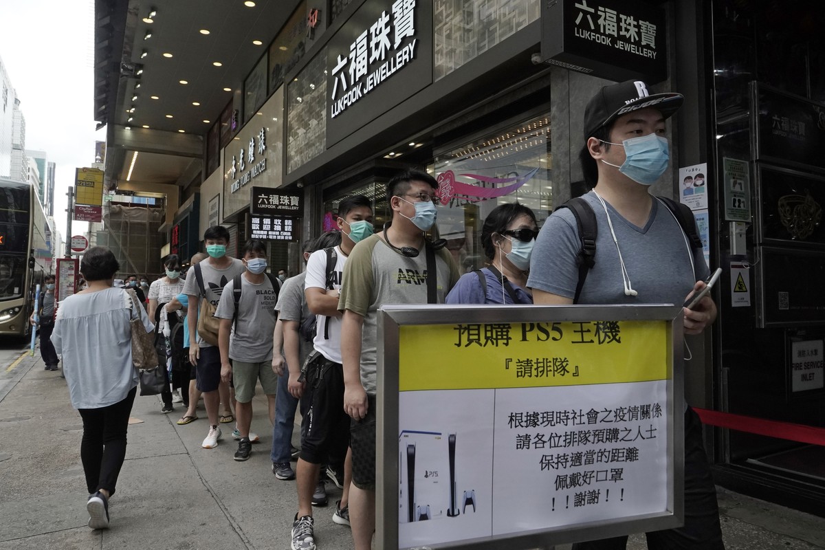 Gaming enthusiasts queue up for the pre-order sales of the newly unveiled Japanese brand video game console, Sony's PlayStation 5 (PS5), outside a retailer in Hong Kong, Friday, Sept. 18, 2020. P ...