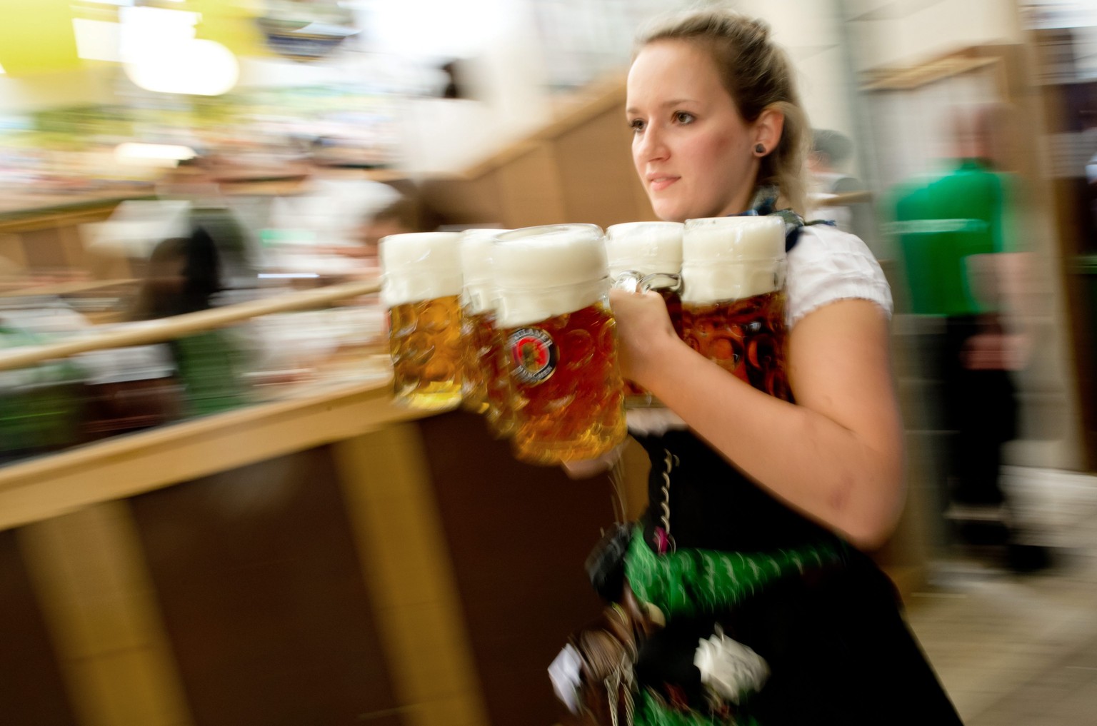 epa04938165 A waitress rushes carrying the first beer mugs in a beer tent at the 182nd Oktoberfest in Munich, Germany, 19 September 2015. Oktoberfest, Germany's annual 16-day extravaganza of heav ...