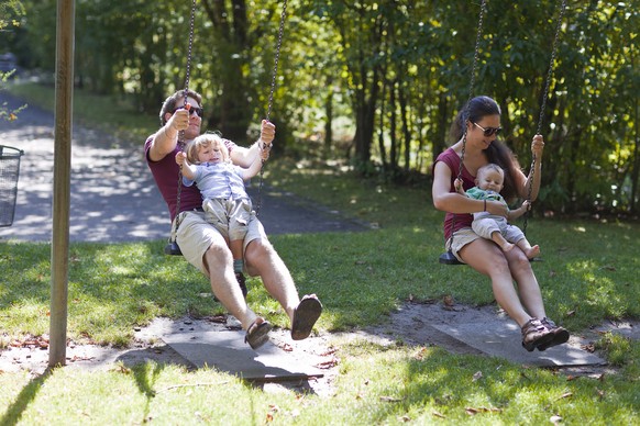 Ich verbringe die ganze Zeit mit meiner Familie. An unmarried couple and their children Marlon (2.5 years, right) and Moris (6 month, left) sit on swings, pictured on September 16, 2011, in Unterfelden in the canton of Aargau, Switzerland. (KEYSTONE/Gaetan Bally)