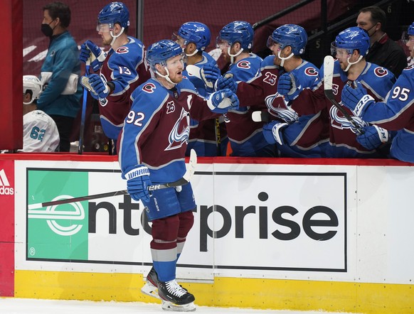 Colorado Avalanche left wing Gabriel Landeskog, front, is congratulated after scoring a goal as he passes by the team box in the first period of an NHL hockey game against the San Jose Sharks, Friday, ...