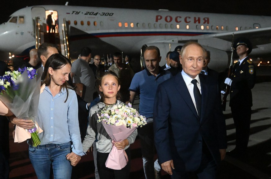 epa11517344 Russian President Vladimir Putin (R) meets Russian citizens released after the Russian-US prisoner swap in Turkiye at Vnukovo International Airport in Moscow, Russia, 01 August 2024. On Au ...