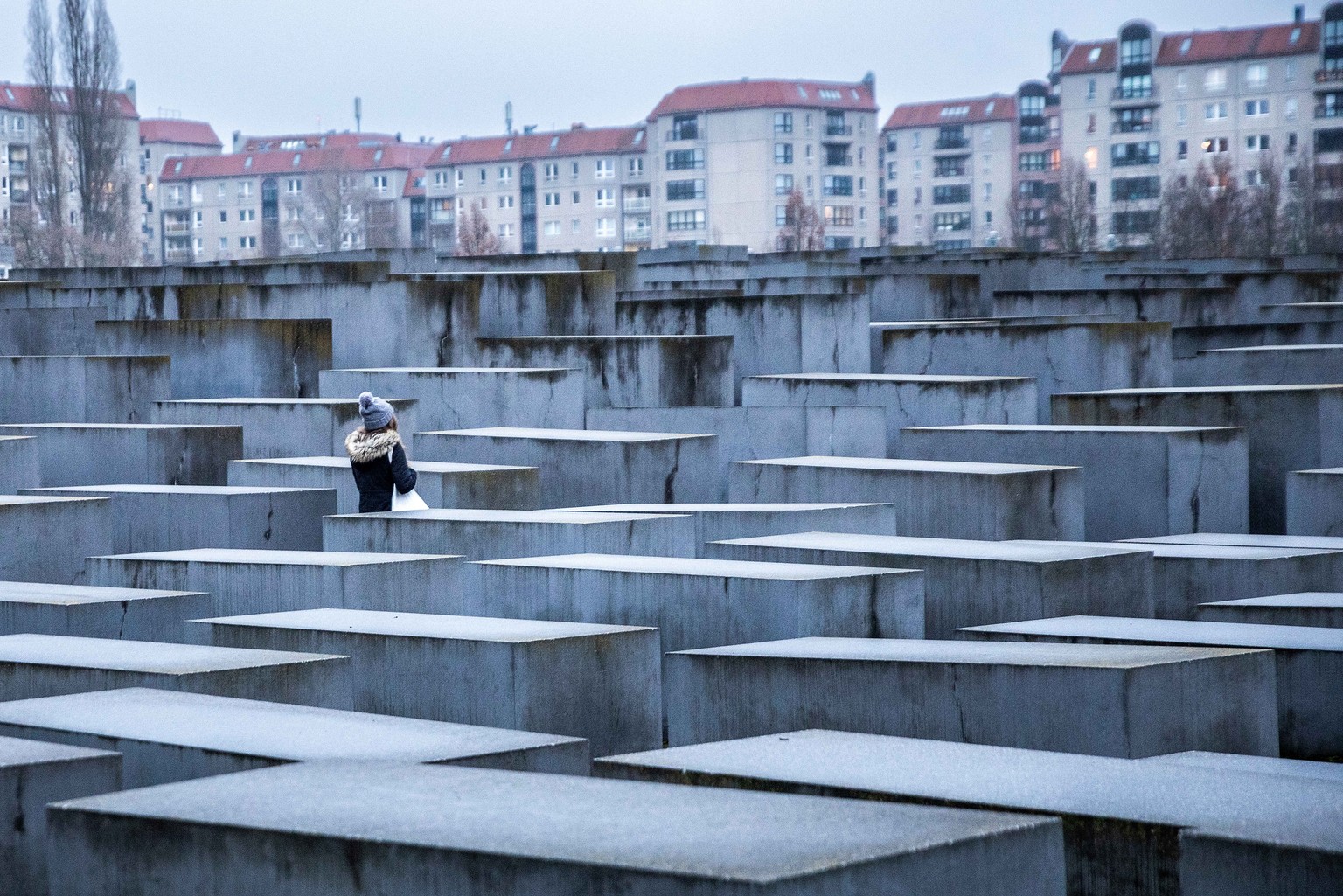 24.01.2022, Berlin: Eine junge Frau steht im Stelenfeld des Mahnmals f�r die ermordeten Juden Europas, das auch Holocaust-Mahnmal genannt wird. Am 27. Januar ist der Internationale Tag des Gedenkens a ...