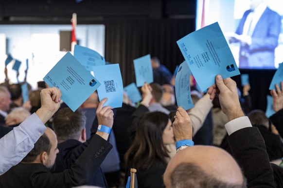 Die Delegierten der FDP bei einer Abstimmung anlaesslich der Delegiertenversammlung der FDP Schweiz vom Samstag, 20. Januar 2024 im Freiraum in Zug.(KEYSTONE/Urs Flueeler).
