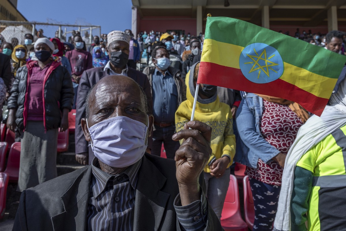A man holds a national flag as he waits in the stands to give blood at a blood drive in support of the country's military, at a stadium in the capital Addis Ababa, Ethiopia Thursday, Nov. 12, 202 ...