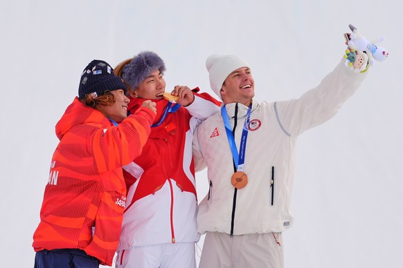 From left, silver medalist Japan's Taiga Hasegawa, gold medalist China's Su Yiming and bronze medalist United States' Jake Canter take a selfie after the men's snowboarding slopest ...