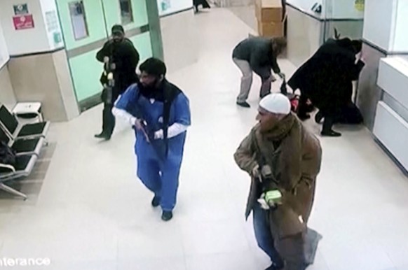 In this image taken from surveillance video provided by the Palestinian Health Ministry, Israeli forces disguised as civilians and medical workers hold weapons in a hallway at the Ibn Sina Hospital in ...