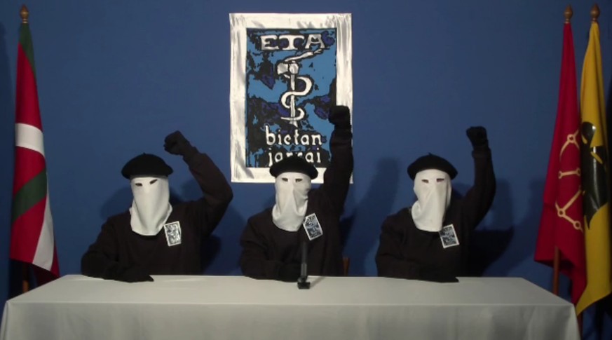 FILE - In this file image made from video provided on Oct. 20, 2011, masked members of the Basque militant group ETA hold up their fists in unison following a news conference at an unknown location. A ...