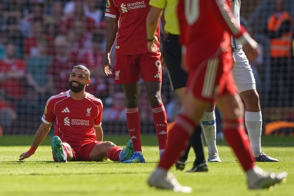 Liverpool's Mohamed Salah smiles as he sits on the pitch after getting injured during the English Premier League soccer match between Liverpool and Crystal Palace in Liverpool, England, Saturday, ...