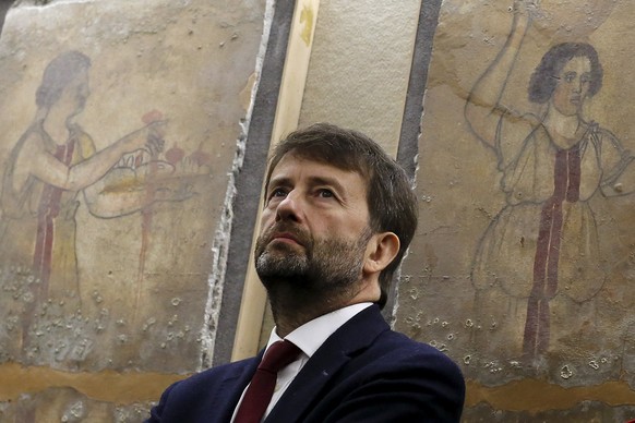 Italy&#039;s Culture Minister Dario Franceschini stands in front of frescoed stone slabs that had been stolen from a tomb in the ancient city of Paestum and were recovered in Rome November 26, 2015. F ...