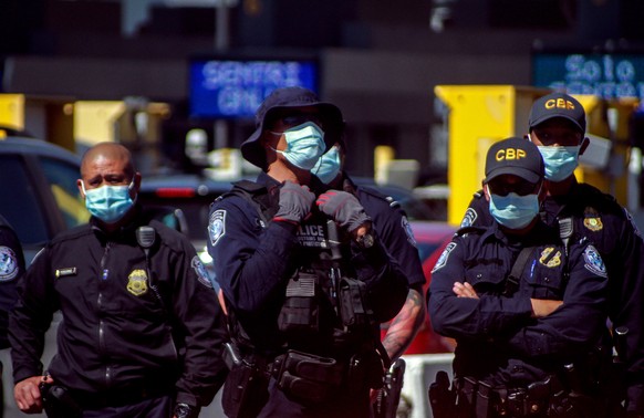 epa09047592 Members of the border patrol stand guard during a migrant demonstration asking US President Joe Biden to enter the country during a demonstration at the checkpoint of San Ysidro, in the bo ...