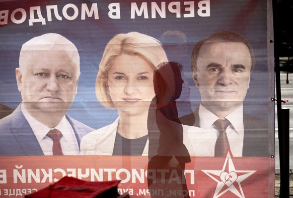 epa12355012 A pedestrian casts a shadow while passing by the campaign tent of the Patriotic Electoral Bloc, in Chisinau, Moldova, 05 September 2025. Modolva&#039;s parliamentary elections are schedule ...