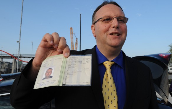 Volker Eckel zeigt seinen Pass.