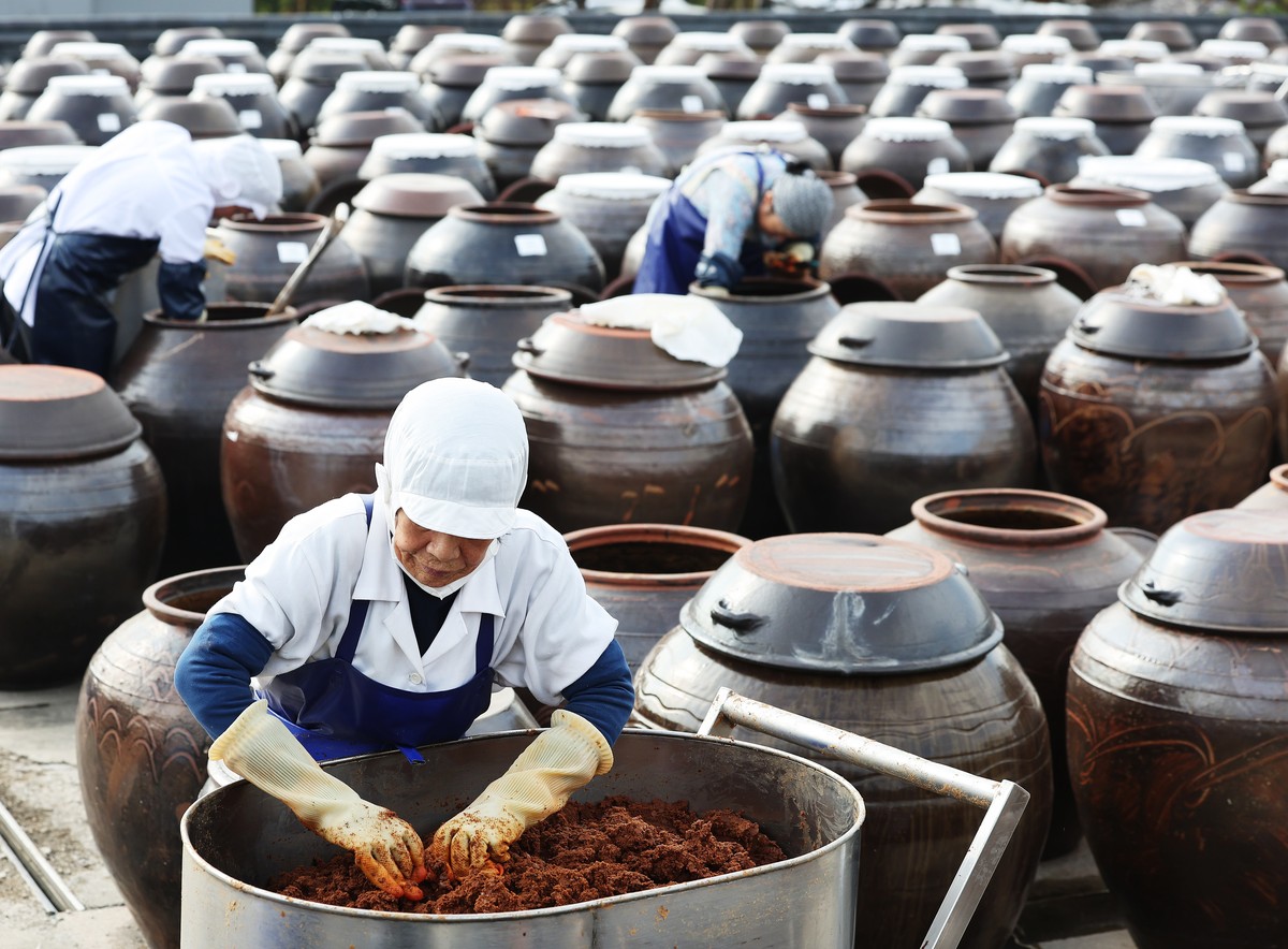 epa11702055 Employees make 'jang' at a traditional Korean outdoor farm for 'doenjang,' a fermented soybean paste, in Anseong, some 65 kilometers south of Seoul, South Korea, 05 Nov ...