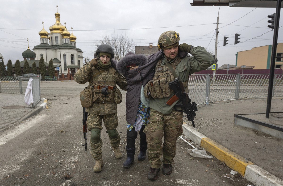 Ukrainian servicemen help an elderly woman, in the town of Irpin, Ukraine, Sunday, March 6, 2022. With the Kremlin's rhetoric growing fiercer and a reprieve from fighting dissolving, Russian troo ...