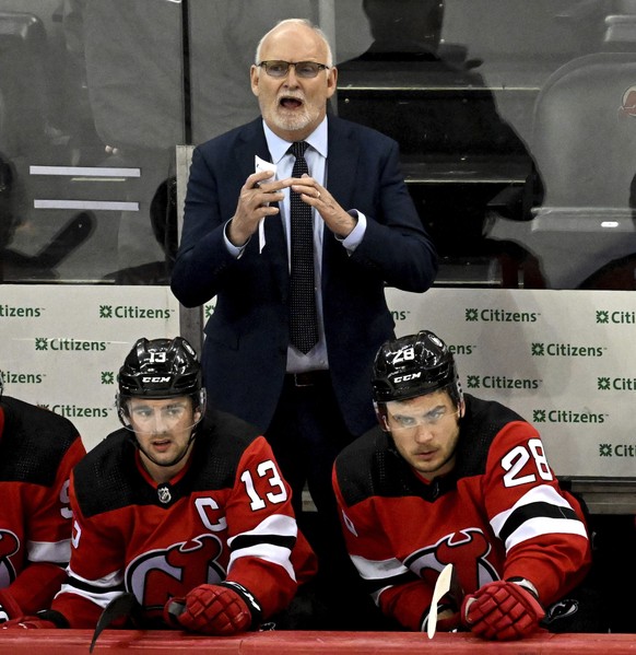 New Jersey Devils coach Lindy Ruff signals for a timeout during the third period of the team&#039;s NHL hockey game against the Calgary Flames on Thursday, Feb. 8, 2024, in Newark, N.J. (AP Photo/Bill ...