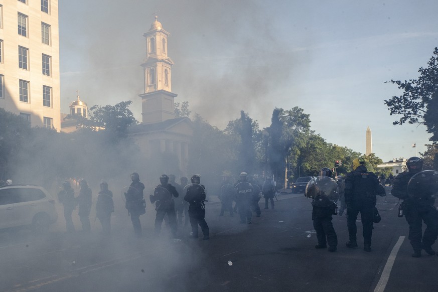 Tear gas floats in the air as a line of police move demonstrators away from St. John&#039;s Church across Lafayette Park from the White House, as they gather to protest the death of George Floyd, Mond ...