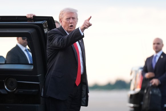 President Donald Trump points before boarding Air Force One at Palm Beach International Airport in West Palm Beach Fla., on his way back to the White House following a weekend at his Mar-a-Lago estate ...