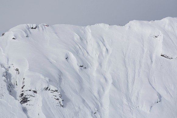 Ein Helikopter mit dem Sprengsatz unterwegs zur Ausloesung einer Lawine, anlaesslich einer Lawinensprengung zu Testzwecken, durchgefuehrt von Lawinenforschern des Eidg. Institut fuer Schnee- und Lawin ...