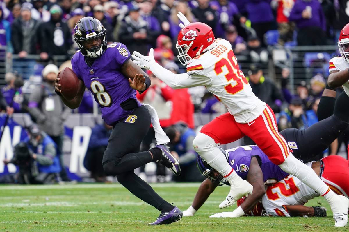 epa11111627 Baltimore Ravens quarterback Lamar Jackson (L) scrambles for yardage while elduding a tackle by Kansas City Chiefs cornerback L'Jarius Sneed (R) during the first half of the AFC confe ...