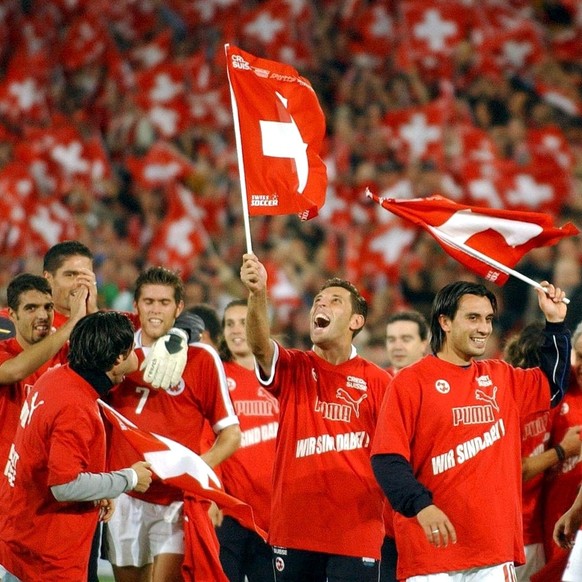 Hakan Yakin, rechts, und Milaim Rama, links, feiern mit Schweizer Fahnen, nach dem Fussball EM-Qualifikationsspiel Schweiz gegen Irland in Basel, am Samstag, 11. Oktober 2003. Mit einem 2-0 hat sich d ...