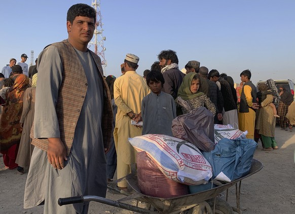 An Afghan man prepares to push a wheelbarrow with items of food distributing by an Islamabad-based Christian organization on the outskirts of Chaman, a border town in the Pakistan&#039;s southwestern  ...