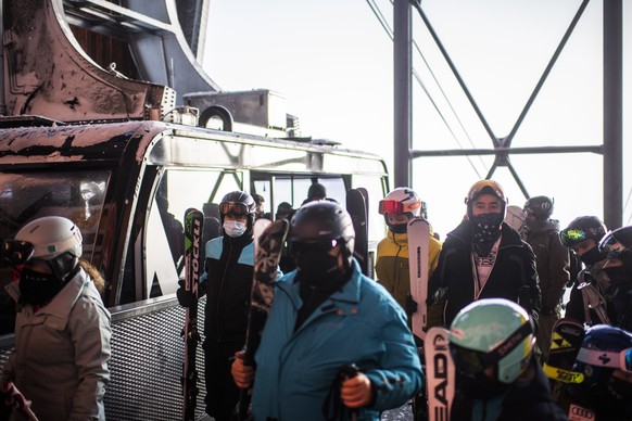 Skifahrer mit Schutzmaske steigen aus der Gondel auf dem Crap Sogn Gion aus, aufgenommen am Samstag, 26. November 2020, im Skigebiet Flims Laax Falera, in Falera. Die Buendner Skigebiete bleiben trotz ...