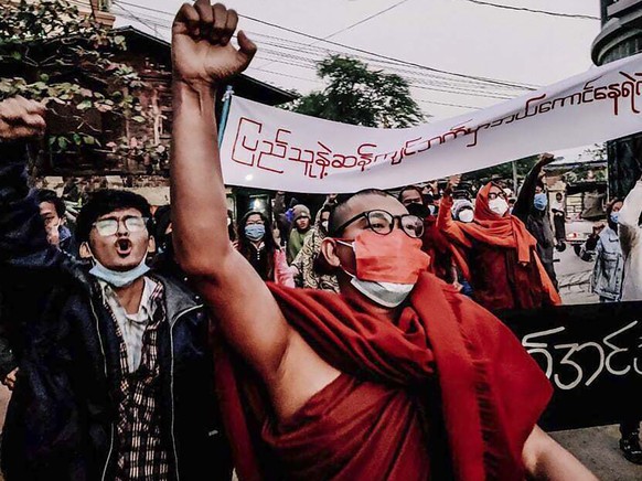 A Buddhist monk raises his clenched fist while marching during an anti-military government protest rally on Tuesday, Feb. 1, 2022, in Mandalay, Myanmar. The new U.N. special envoy for Myanmar says vio ...